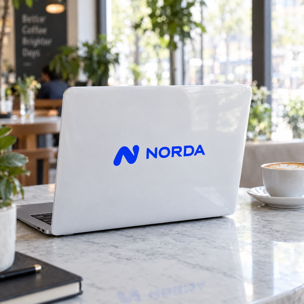 BackBrand Hardcase mit blauem Logo auf weißem Hintergrund im Café (Darstellung)