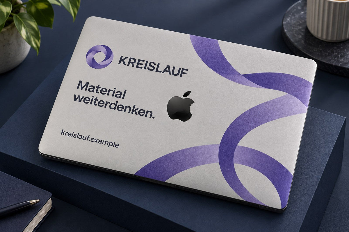 MacBook-Skin in Violett mit Logo und Domain, im Studio fotografiert. AI-generiertes Bild.